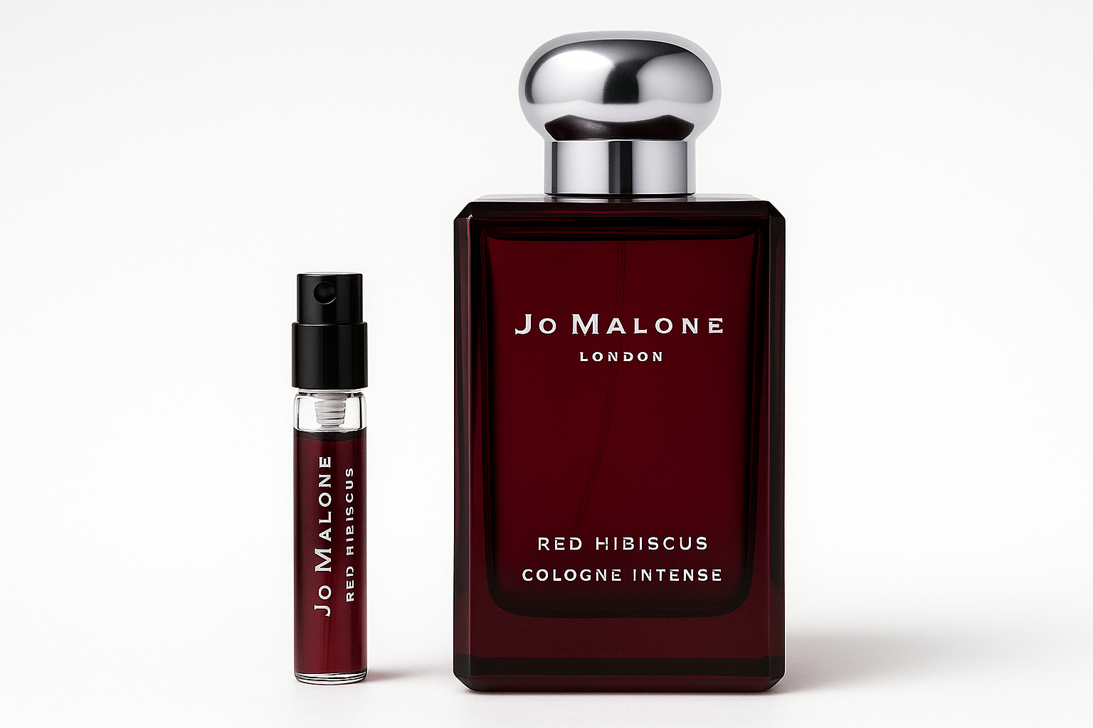 Jo Malone Red Hibiscus Cologne Intense 2ml sample standing next to 100ml perfume bottle of Jo Malone Red Hibiscus Cologne Intense which has white writing on dark red bottle